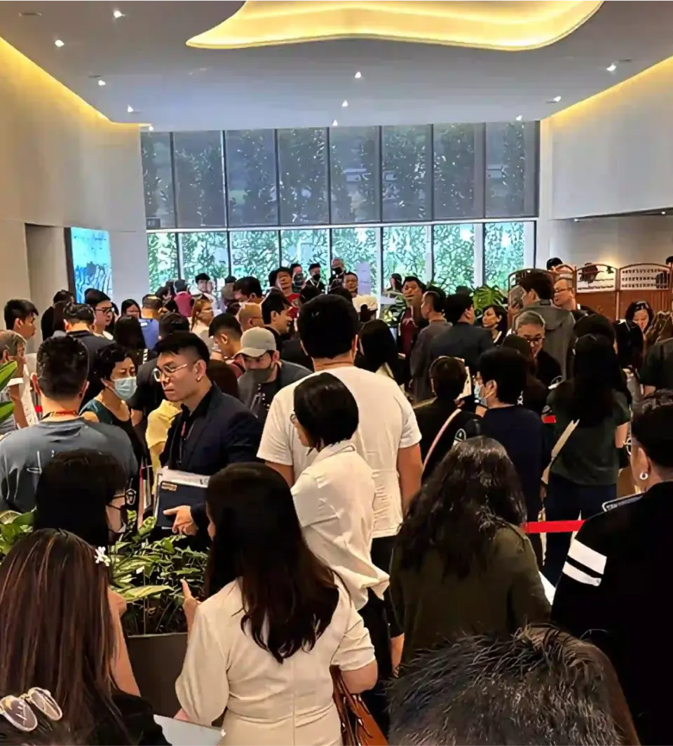 Showflat Opening Event: A bustling, energetic gathering of people indoors, showing Hillhaven's showflat opening.